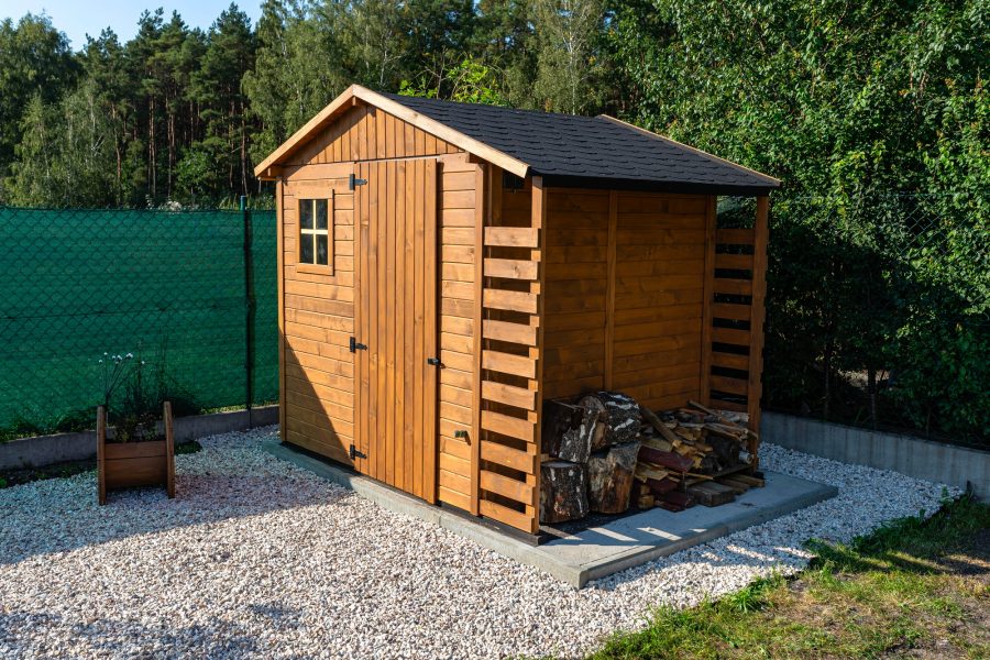 A wooden garden shed standing on a concrete foundation in a garden. A wooden garden shed standing on a concrete foundation in a garden.