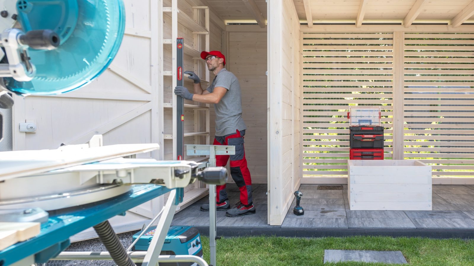 Man Leveling Shelf Unit in Garden Shed Man Leveling Shelf Unit in Garden Shed