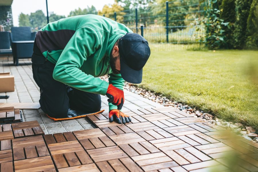 Woodworking on the terrace: a man laying the floor Woodworking on the terrace: a man laying the floor